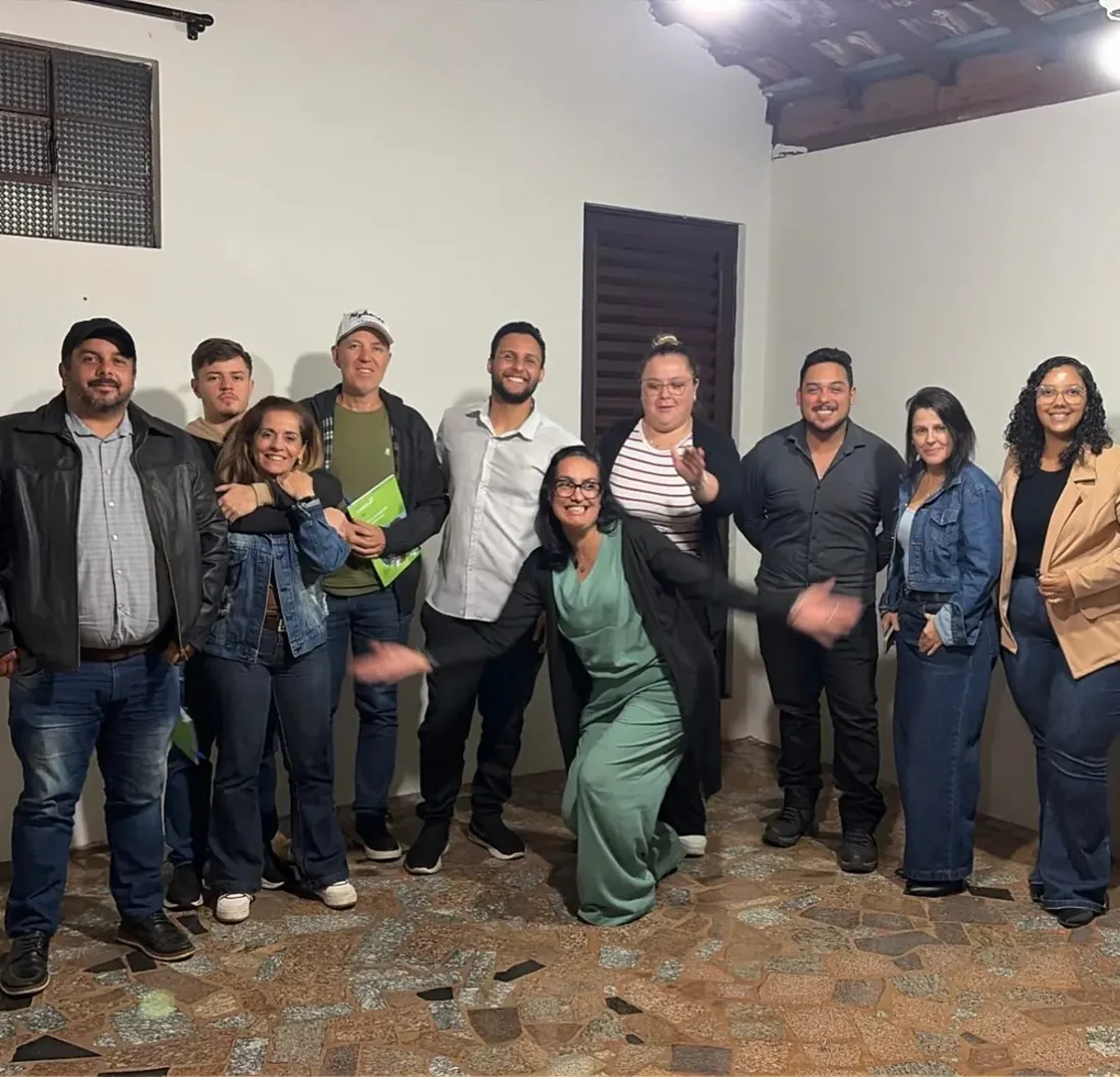 Turma de IA da Alpha Fox em Brotas, com participantes sorrindo após o encontro, alguns segurando o material da turma